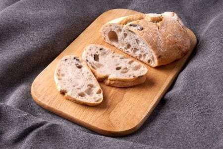 Ciabatta cut into slices on a wooden cutting board.の写真素材