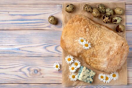 Homemade ciabatta in baking paper,  gorgonzola cheese and quail eggs.の写真素材