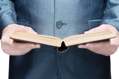 Man in a suit holding an open book on a white backgroundの写真素材