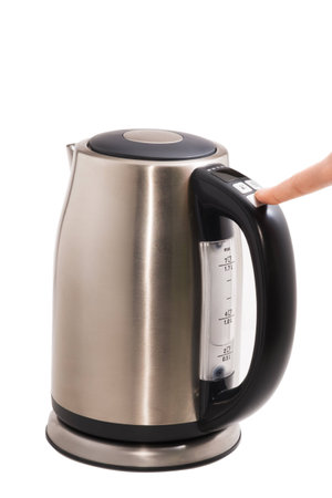Steel electric kettle, with finger presses the button on a white backgroundの写真素材