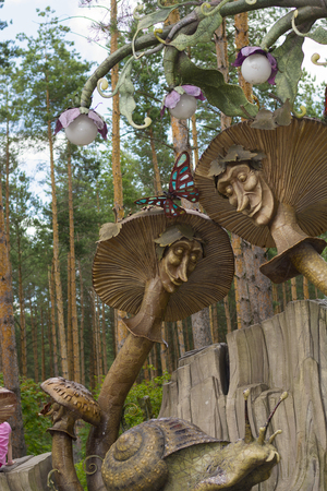 RYAZAN, RUSSIA - 19 JULY, 2017: Children's playground with toadstools with eyes, snails, flowers and other animals. Ryazan Amusement Park "In a certain kingdom". Two merry toadstools and a snail in the background of treesのeditorial素材