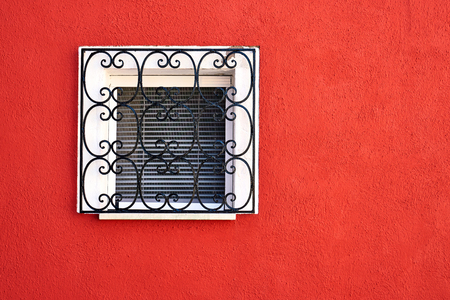 Window with lattice on red wall. Italy, Venice.の写真素材