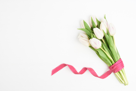 White tulips bouquet on white wooden background. Copy space, top viewの写真素材