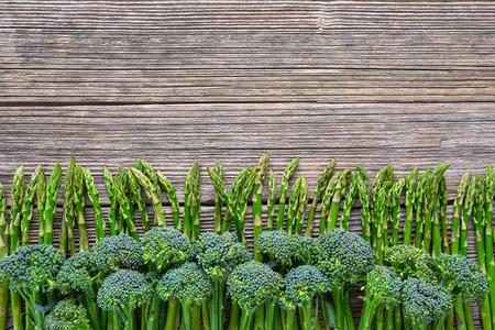Organic food. Green broccoli and asparagus on rustic wooden background. Top view, copy space. Healthy food background.の写真素材