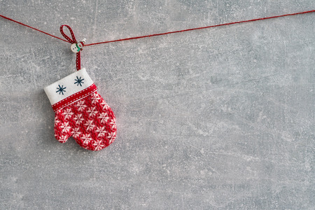 Red Christmas decoration on gray background. Red mitten witn ornament. Copy spaceの写真素材