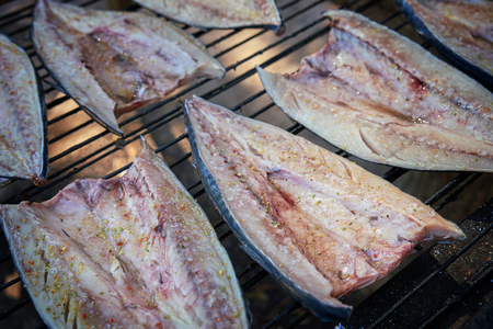 Fish Smoking Process. Smoked Mackerel with herbs and garlic. Close Up Smoking. View from above, selective focusの写真素材