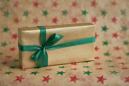 Golden gift or present box decorated with green ribbon on colorful background. Copy space. Holiday concept. Christmas greeting card.の写真素材