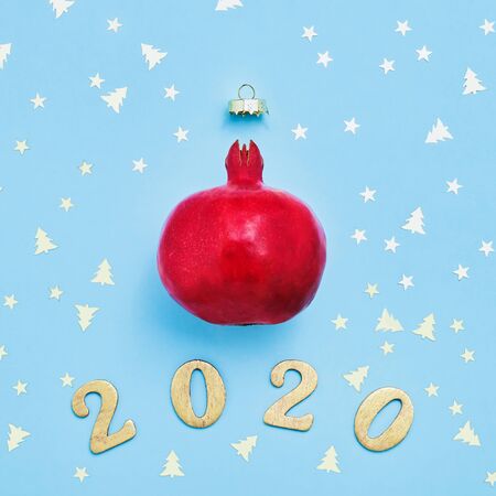 Christmas greeting card with pomegranate and golden glitters on blue background