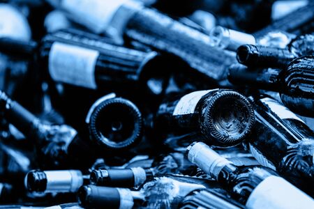 A large heap of empty wine bottles. Garbage. Recycle concept. Color of the year 2020 classic blue toned. Ecologyの写真素材