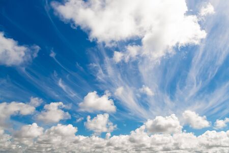 Fluffy white clouds across blue sky. Copy space for text