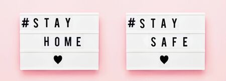 STAY AT HOME, STAY SAFE written in light box on pink background. Healthcare and medical concept. Top view. Quarantine concept. Bannerの写真素材