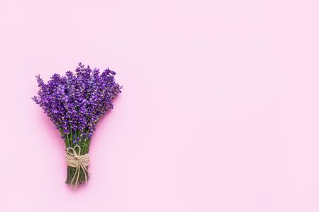 Bunch of fresh lavender on pink background. Violet flowers. Greeting floral card with place for text. Flat lay, copy space.の写真素材