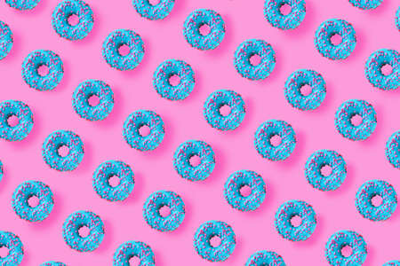 Pattern of a blue donuts on a bright pink background. Flat layの写真素材