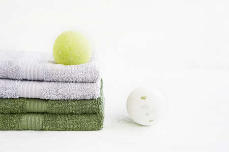 SPA concept. Two bath bombs and stack of four bath towels on light background. Copy space for text.の写真素材