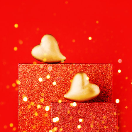 Golden hearts on a red podium with copy space. Valentines Day celebration conceptの写真素材
