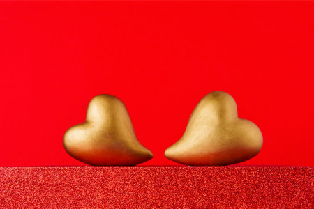 Golden hearts on a red podium with copy space. Valentines Day celebration conceptの写真素材