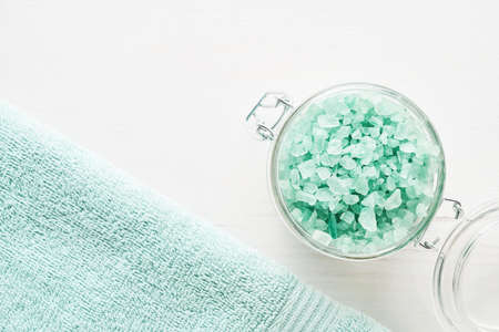 Bath salt and towel on a white wooden background. SPA, hygiene, wellness well-being, body care concept. Copy space, flat layの写真素材