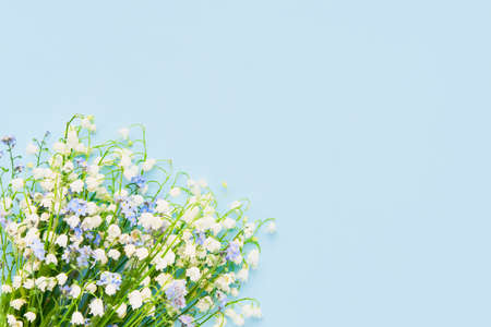 Bouquet of lily of the valleys on a light blue background. Mothers Day, birthday celebration...