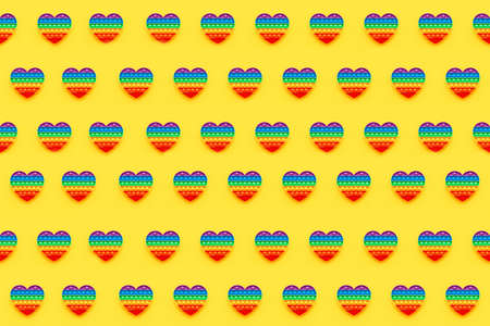 Pattern. Colorful trendy heart shape fidgets toy for kids on a yellow background.の写真素材
