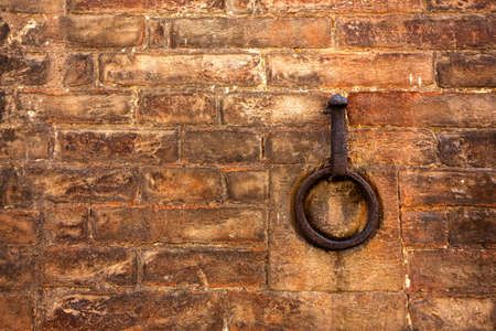 A rusty metal ring embedded in a red brick wall. Copy space for textの写真素材
