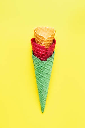 Various empty ice cream cones on a bright yellow background. Summer concept, top viewの写真素材
