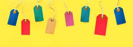Banner of colorful sale tags on a bright yellow background. Discounts and Black Friday concept. Top viewの写真素材