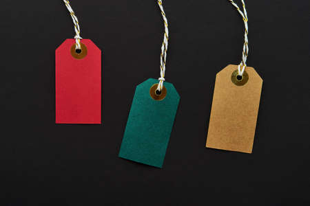 Colorful sale tags on a black background. Sale and Black Friday concept. Top view, copy spaceの写真素材