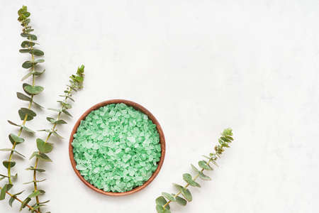 Eucalyptus bath salt and twigs of fresh eucalyptus on a white marble background. SPA, body care concept. Copy spaceの写真素材