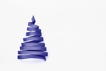 Christmas tree made from lilac ribbon on white background. Very Peri 2022 color. Copy spaceの写真素材