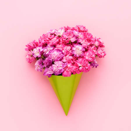 Pink carnation flowers bouquet on a pink background. Greeting card. Flat lay, copy spaceの写真素材