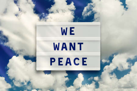 WE WANT PEACE written in a lightbox on clouds sky background. No war conceptの写真素材