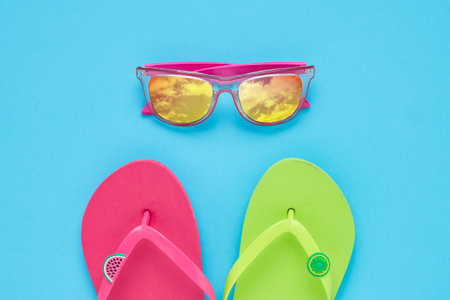 Summer vacation concept. Beach accessories , Flip-flops and sunglasses on a blue background