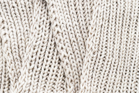Knitting. Vertical striped beige knit fabric texture, knitted pattern background. Top view