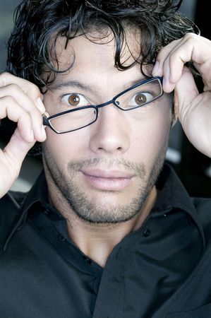 young man fixing his glassesの写真素材