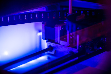 Working with 3D printer in the laboratory and studying technology. Printer is heating up. Macro shot of 3D printer, while printing a plastic product prototype by using white ABS filament. Innovation.の写真素材
