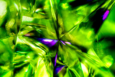 Abstract, blurry, vibrant and colorful background. Macro shot of a green Christmas star on a lit Christmas Treeの写真素材