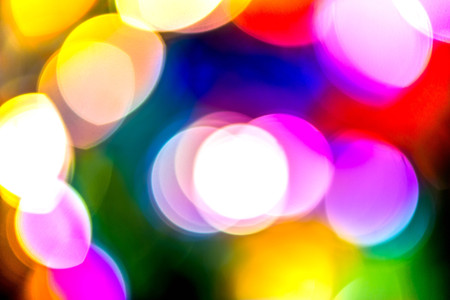 Abstract, blurry, vibrant and colorful background. A shot of Christmas lights on a lit Christmas Treeの写真素材