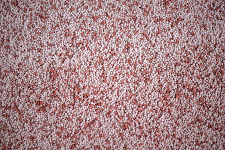 Shot of mixed chemical, artificial nitrogen plant fertilizer granules in factory. Big heaps of mineral pellets creating abstract textures, patterns. Minerals used in agriculture, farms, fieldsの写真素材