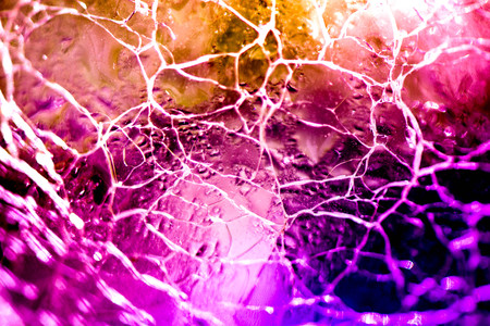 Macro shot of broken, cracked glass ball on colorful rainbow background. Glass reflecting light on sunny summer day. Future prediction, fortune telling in crystal ball. Abstract, esoteric background.の写真素材