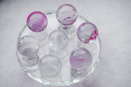Macro shot of transparent crystal balls with colorful ornaments and sun reflections in it, on turquoise glass pad. Fortune telling. Love, money, luck, success.の写真素材
