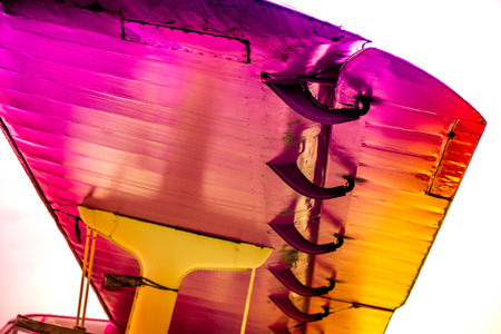Abstract, old yellow, pink, purple plane in abandoned airport next to dark forest in an overcast day.の写真素材