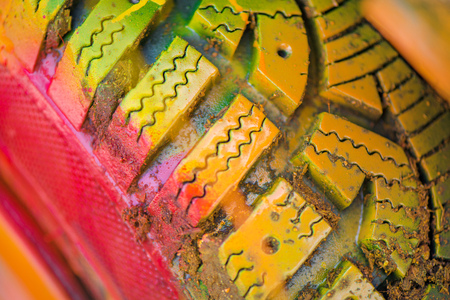 Macro shot of a painted tire. Kids are having fun, making drawings and graffiti art, paint on  tires with green, red, orange, yellow, blue colorsの写真素材
