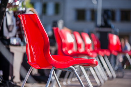 Red chairs in a row on stage on sunny summer day. Entertainment eventsの写真素材
