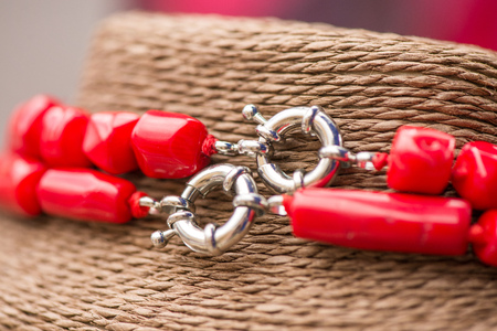 Silver clasp on a red coral stone and crystal necklace. Beautiful, polished gemstones on natural rustic background, Healing, powerful energy for crystal therapy treatments, reiki. Esoteric backgroundの写真素材
