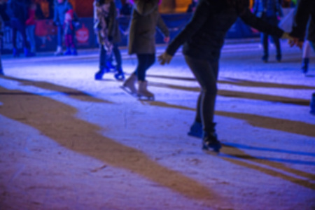 Abstract blurry background of ice skating people in city center during Christmas marketの写真素材