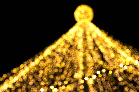 Abstract Christmas tree, colorful, blurry background. Glowing and sparkling lights in city center in Christmas marketの写真素材