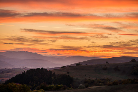 Romantic, bright and colorful sunset over a mountain range in Transilvania. Beautiful, colorful autumn backgroundの写真素材