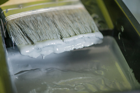 Macro shot of dripping grey color. Tray liner and paint during renovation in houseの写真素材