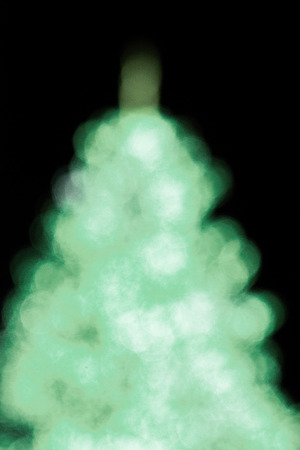 Abstract Christmas tree, colorful, blurry background. Glowing and sparkling lights in city center in Christmas marketの写真素材
