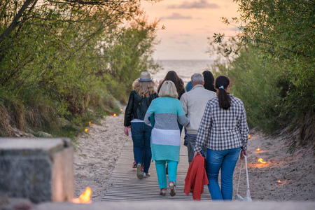 Romantic bonfire night at seaside during sunset. People gathering together to celebrate Night of ancient lights. Large burning campfire with soft glowing flame and sparkles in the background.の写真素材